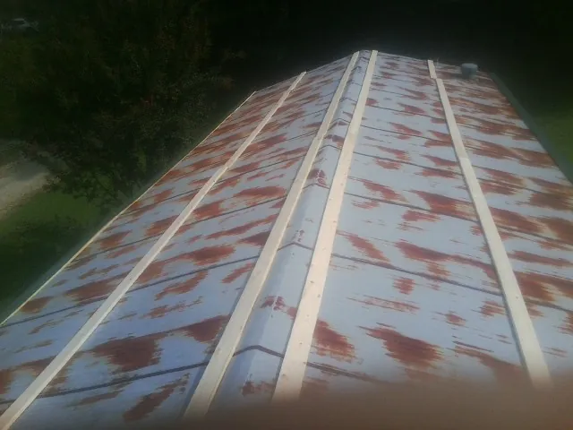 Rusted metal roof panels with new wood purlins before replacement — Storm Damage Roof Repair in Ledyard by Roofing Brothers