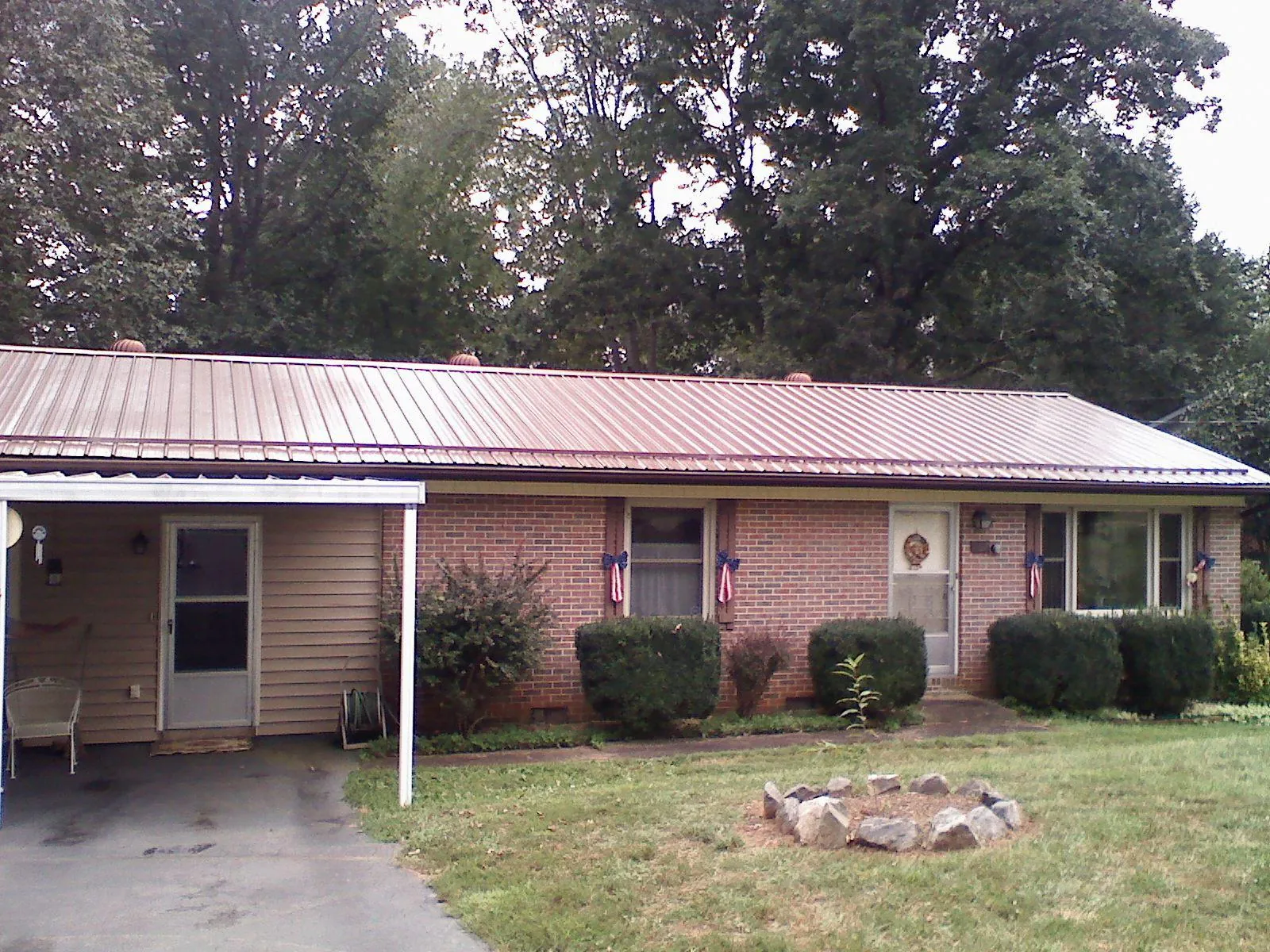 Bronze metal roof and carport on a brick ranch home — Roof Repair work by our crew in Ledyard