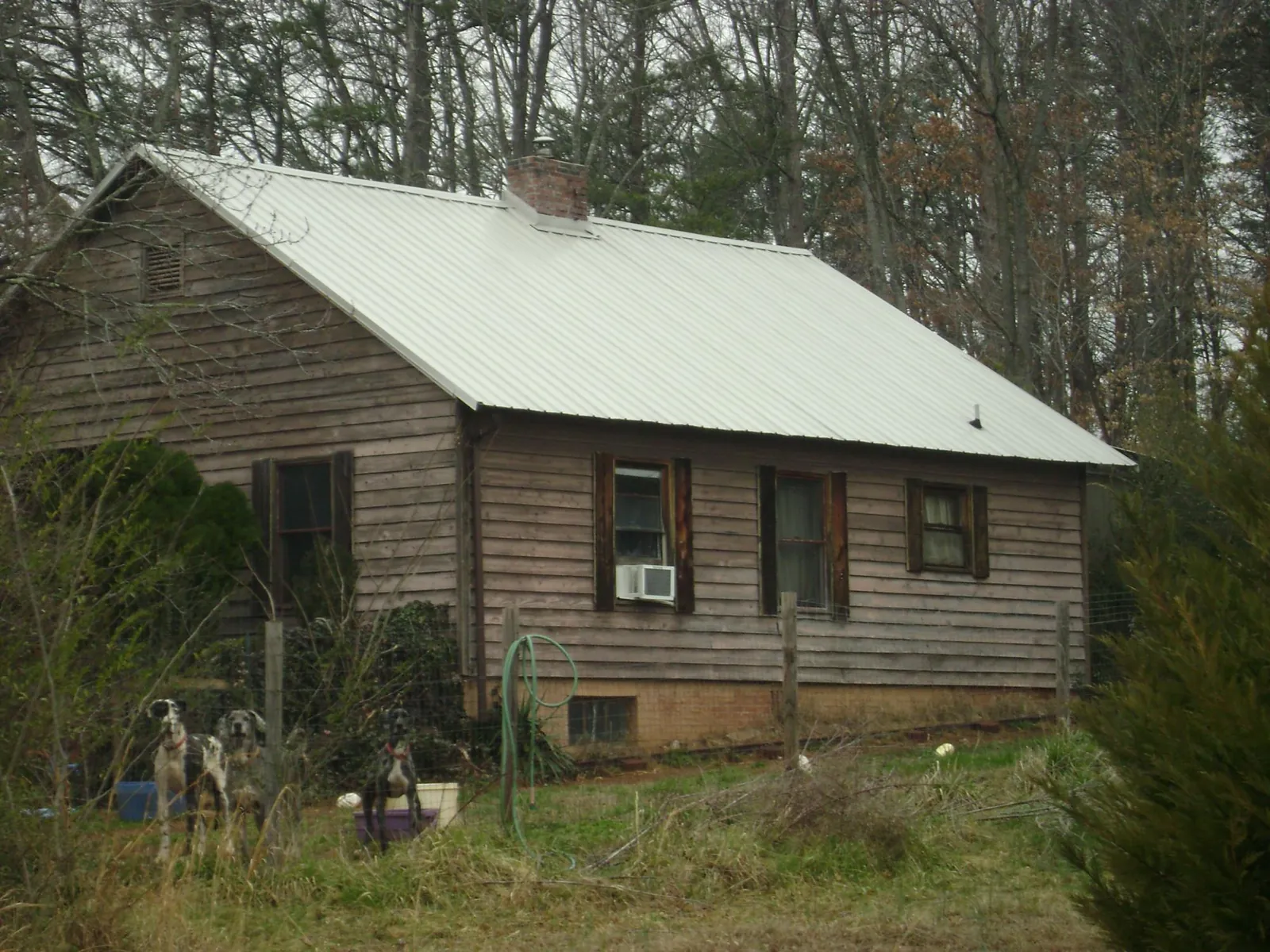 White metal roof on an old wood sided farmhouse, from a Metal Roof Installation job in Ledyard